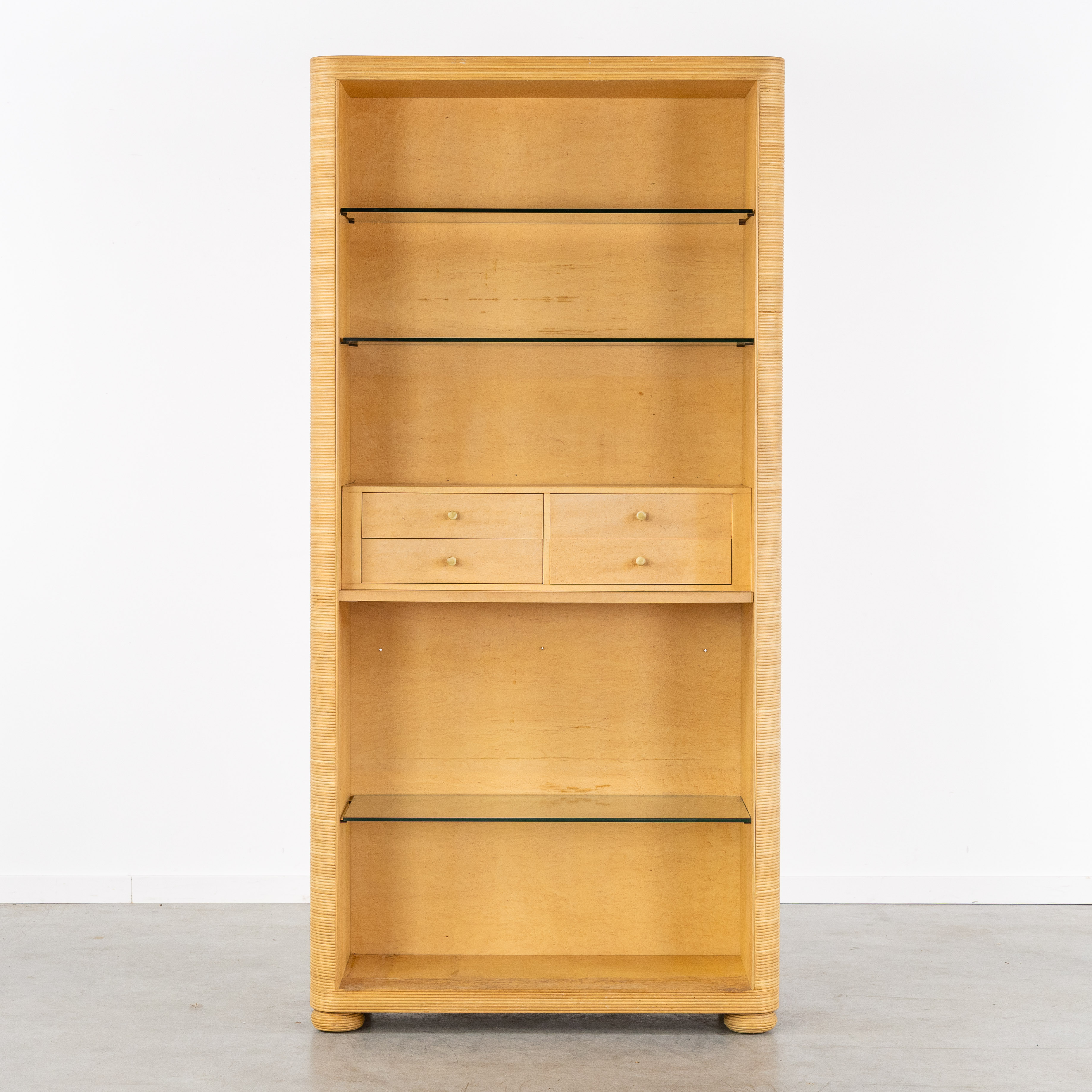 Een bibliotheekkast met afgeronde hoeken en glazen leggers, pencil reed, esdoorn fineer, circa 1980. (L:95.5 x W:40 x H:195 cm)